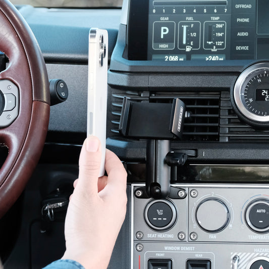 Image of Offroam Phone Mount installed securely in INEOS Grenadier 2022-2025. This premium phone mount installs easily without drilling or glue. Spring loaded Universal holder for use with any phone. Perfect placement without blocking screens, driver view, or air flow. Fully adjustable positioning.