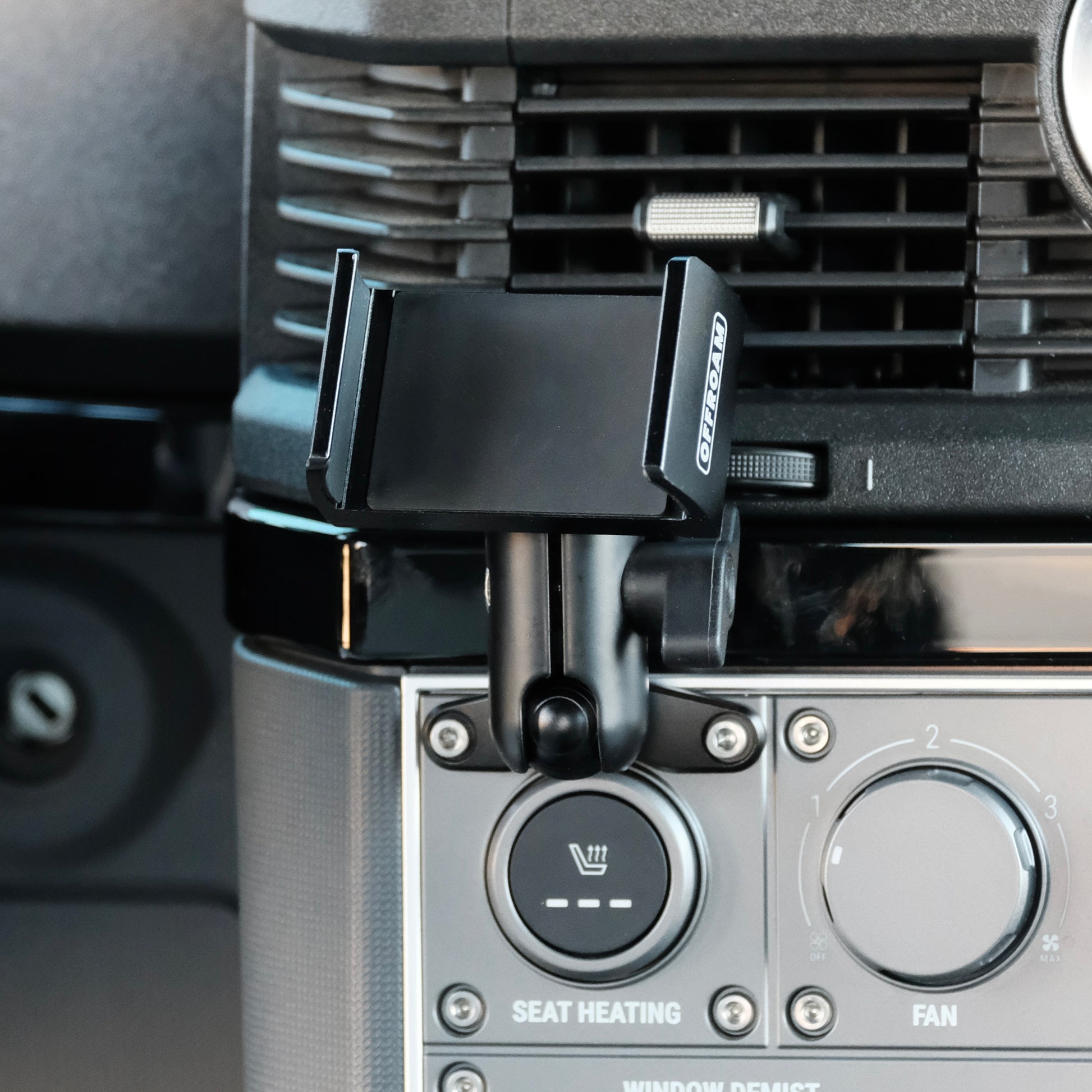 Image of Offroam Phone Mount installed securely in INEOS Grenadier 2022-2025. This premium phone mount installs easily without drilling or glue. Spring loaded Universal holder for use with any phone. Perfect placement without blocking screens, driver view, or air flow. Fully adjustable positioning.