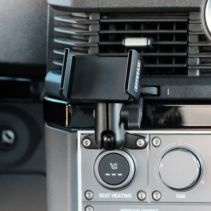 Image of Offroam Phone Mount installed securely in INEOS Grenadier 2022-2025. This premium phone mount installs easily without drilling or glue. Spring loaded Universal holder for use with any phone. Perfect placement without blocking screens, driver view, or air flow. Fully adjustable positioning.