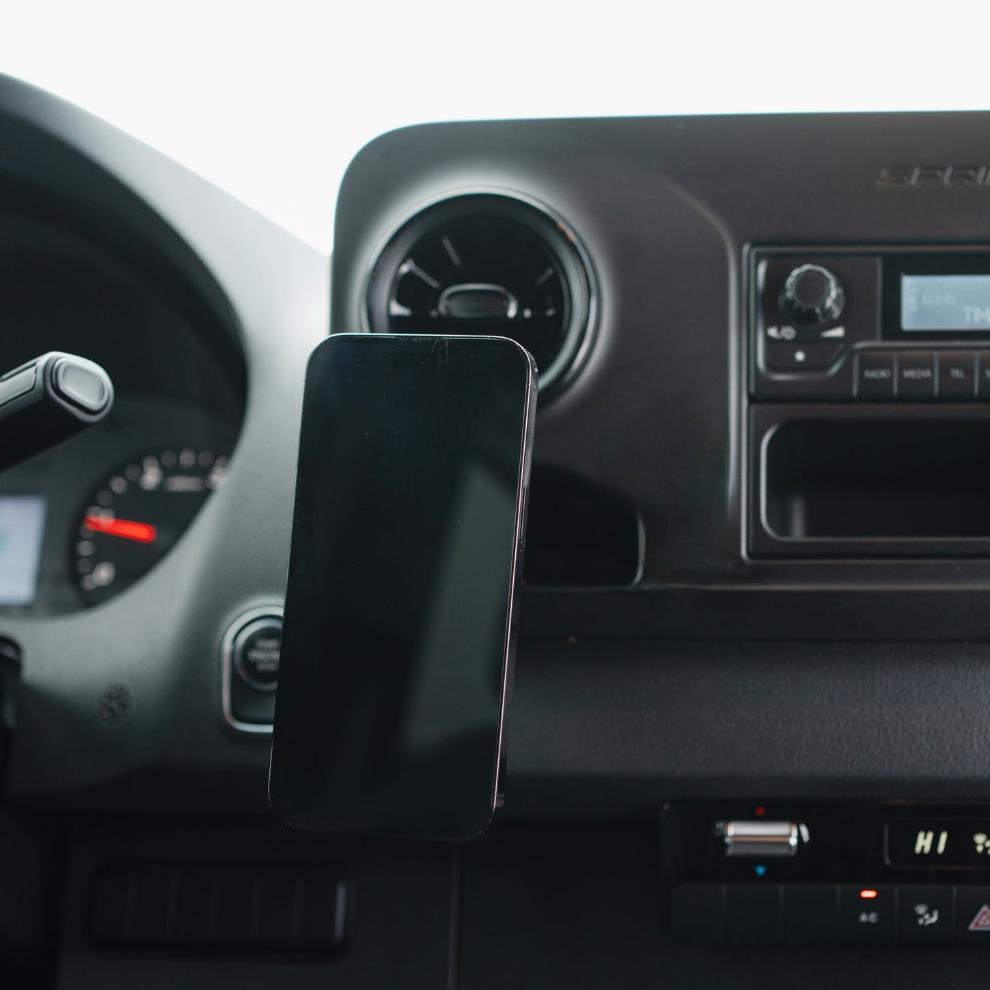 Image of Offroam MagSafe-compatible Phone Mount installed securely in Mercedes-Benz Sprinter 2019-2026. This premium phone mount installs easily without drilling or glue. High force magnets hold phone on any trail, road, or track. Perfect placement without blocking screens, driver view, or air flow. Fully adjustable positioning.