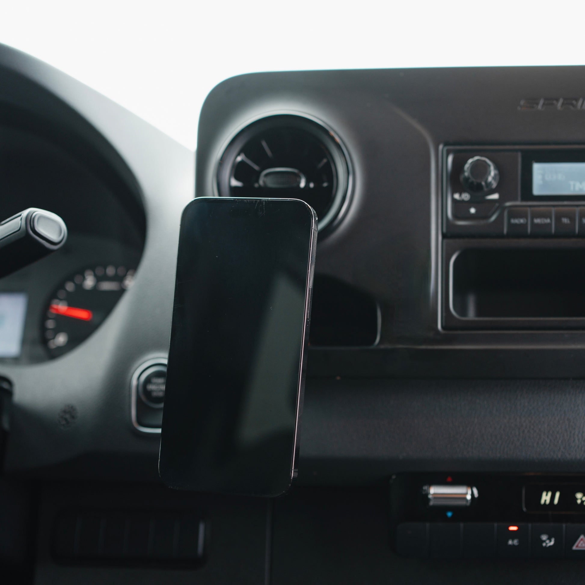 Image of Offroam MagSafe-compatible Phone Mount installed securely in Mercedes-Benz Sprinter 2019-2026. This premium phone mount installs easily without drilling or glue. High force magnets hold phone on any trail, road, or track. Perfect placement without blocking screens, driver view, or air flow. Fully adjustable positioning.