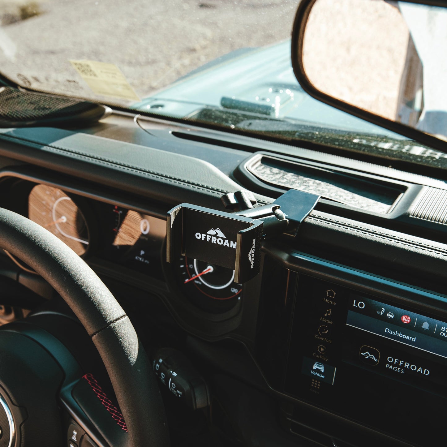 Secure all-metal off-road phone mount with an OEM look a premium Jeep accessory - seamlessly integrated into a 2024-2025 Jeep Wrangler or Jeep Gladiator, holding a smartphone with a spring-loaded holder for optimal positioning during off-road exploration.